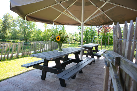 Mesa de picnic al aire libre con flores bajo sombrilla en Castle the Pond Gate, Holiday Park 't Rheezerwold.