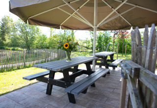 Picknicktisch mit Blumen unter Sonnenschirm im Castle the Pond Gate, Holiday Park 't Rheezerwold, Niederlande.