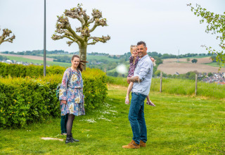 Familia disfrutando de la vista en Treelodge, Gulperberg, Países Bajos, rodeada de campos y colinas verdes.