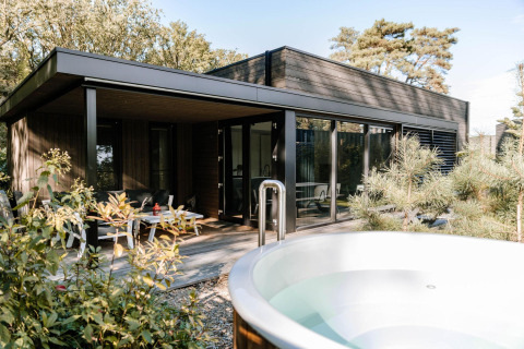 Luxe lodge met moderne architectuur en buitenspa bij Soof Retreats in Nederland, omringd door natuur.