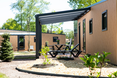Buitenruimte aan Forest lodge tiny house in Holiday Park 't Rheezerwold, Nederland, met moderne veranda.