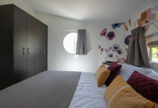 Schlafzimmer in einem Tiny House im Forest Lodge, Holiday Park 't Rheezerwold, Niederlande, modern eingerichtet.