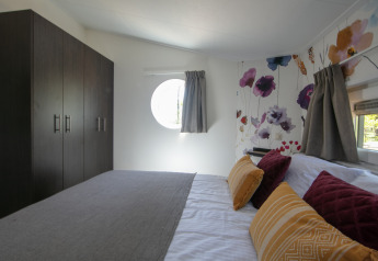 Chambre d'une tiny house à Forest lodge, Holiday Park 't Rheezerwold, Pays-Bas, décoration moderne et florale.
