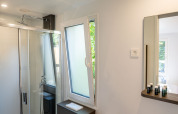 Bagno moderno in una tiny house Lodge a Urban-Gardens, Belgio, con doccia, wc e lavabo compatto.