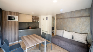 Moderne Lodge bei Urban-Gardens in Belgien, ausgestattet mit Küche, Essecke und komfortablem Sofa.