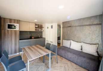 Moderne lodge bij Urban-Gardens in België met open keuken, eethoek en een comfortabele zitbank.