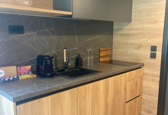 Cocina moderna de tiny house en Urban-Gardens, Bélgica, con muebles de madera y cafetera.