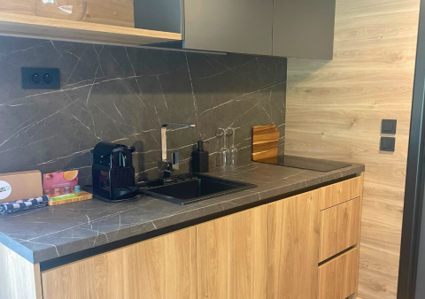 Cucina moderna di tiny house a Urban-Gardens, Belgio, con mobili in legno e macchina da caffè.