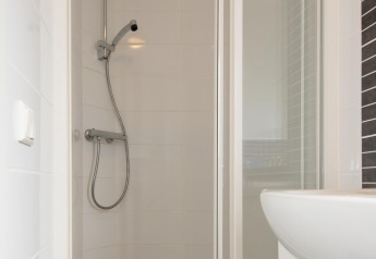 Bagno moderno con cabina doccia e doccetta a Comfort Lodge, Kompas Camping Westende, Belgio.