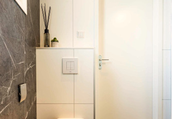 Baño moderno con inodoro de pared, difusor y cactus, en Silva Wellness, Bospark Ede, Países Bajos.