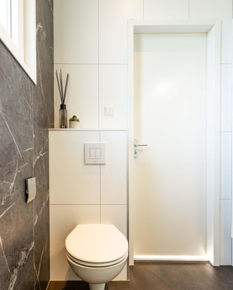 Modernes Badezimmer mit wandhängender Toilette und Dekoration, aufgenommen in Silva Wellness im Bospark Ede.