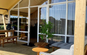 Tenda safari Luna Lodge al Camping the Noetselerberg, Paesi Bassi, terrazza in legno e arredi moderni.