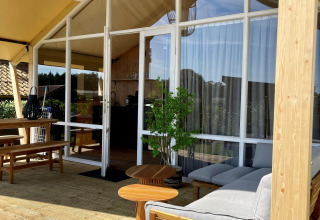 Tenda safari Luna Lodge al Camping the Noetselerberg, Paesi Bassi, terrazza in legno e arredi moderni.