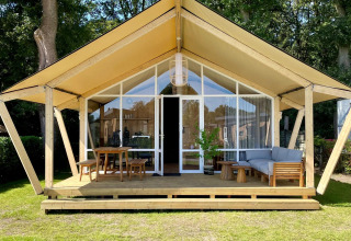 Safaritent Luna Lodge bij Camping de Noetselerberg in Nederland met houten veranda en tuinmeubels.