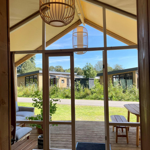 Vista dalla tenda safari Luna Lodge al Camping the Noetselerberg, con lodge moderni nei Paesi Bassi.