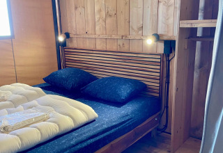Dormitorio de una tienda safari en Luna Lodge, Camping the Noetselerberg en los Países Bajos con cama.