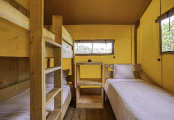 Interior of Stardust 40 Family Lodge safari tent with bunk bed and twin beds at Arden Parks, Signy l'Abbaye.