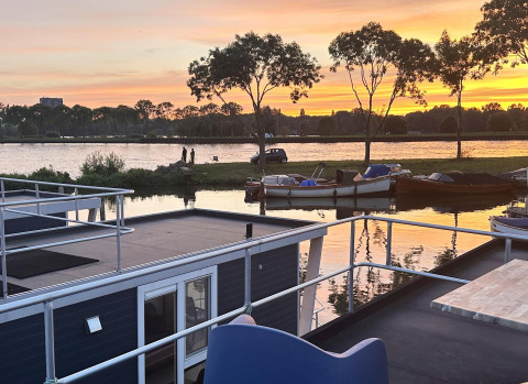 Vista al atardecer desde una casa flotante llamada Harbour Lodge Amsterdam en Marina Parcs Amsterdam, Países Bajos.