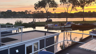 Vista al atardecer desde una casa flotante llamada Harbour Lodge Amsterdam en Marina Parcs Amsterdam, Países Bajos.