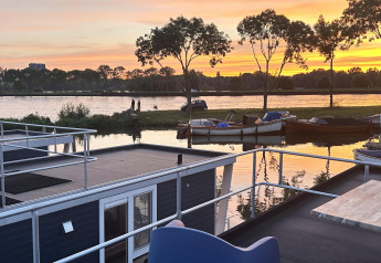 Vista al atardecer desde una casa flotante llamada Harbour Lodge Amsterdam en Marina Parcs Amsterdam, Países Bajos.