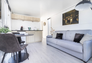 Licht interieur van woonboot met moderne keuken, eettafel en zetel bij Harbour Lodge Amsterdam, Marina Parcs.