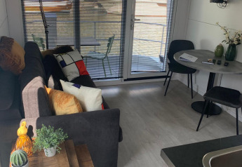 Sala de estar en una casa flotante en Harbour Lodge Amsterdam con decoración moderna y vistas a la marina.