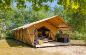 Tente Safari lodge XL à Marina Parcs Almere aux Pays-Bas, entourée d'arbres verdoyants et de nature.