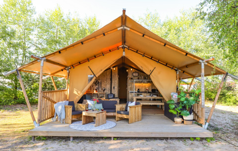 Safari Lodge XL bij Marina Parcs Almere, Nederland, met open safaritent, houten terras en zitmeubels.