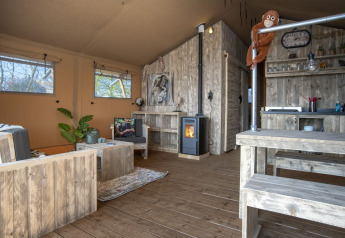 Intérieur du Safari lodge XL à Marina Parcs Almere, Pays-Bas, avec mobilier en bois et ambiance chaleureuse.