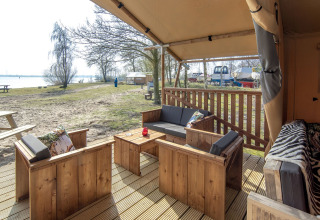 Buitenveranda met houten zitmeubels bij Safari lodge XL, Marina Parcs Almere, Nederland, zicht op meer