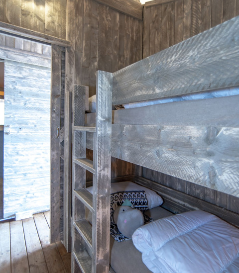 Chambre douillette avec lits superposés dans une tente Safari Lodge XL à Marina Parcs Almere, Pays-Bas.
