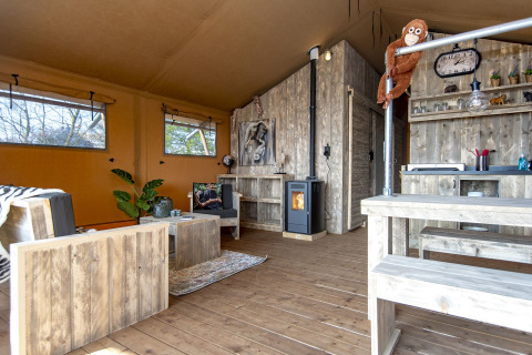 Intérieur du Safari lodge XL à Marina Parcs Almere, Pays-Bas, avec mobilier en bois rustique et décor chaleureux.