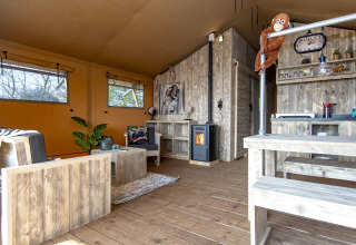 Intérieur du Safari lodge XL à Marina Parcs Almere, Pays-Bas, avec mobilier en bois rustique et décor chaleureux.