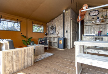 Interior de la Safari lodge XL en Marina Parcs Almere, Países Bajos, con muebles rústicos de madera.