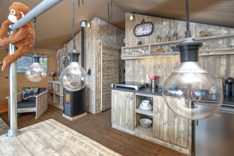 Indvendig i en safari lodge XL telt, Marina Parcs Almere, Holland, med rustikt køkken og træmøbler.