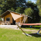 Lodge Villatent Outback au Camping Au Clos de La Chaume en France avec hamac et cadre verdoyant ensoleillé.