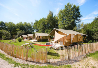 Villatent Outback tenten op Camping Au Clos de La Chaume in Frankrijk, met veel groen en houten hek.