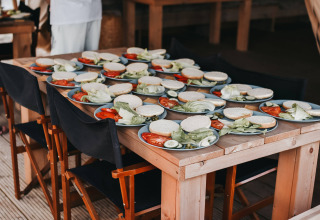 Plates with sandwich ingredients on a wooden table at Camping Luna del Monte holiday park in Umbria, Italy.