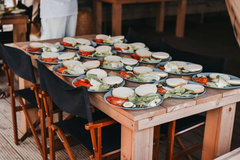 Plates with sandwich ingredients on a wooden table at Camping Luna del Monte holiday park in Umbria, Italy.