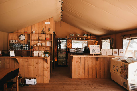 Accogliente caffetteria interna al Camping Luna del Monte in Umbria, Italia, con arredi in legno e menù esposti.