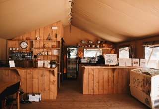 Cozy indoor café at Camping Luna del Monte, Umbria, Italy, featuring wooden decor and displayed menus.