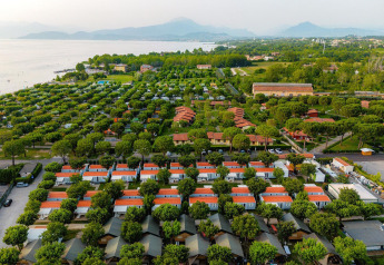 Luchtfoto van safaritenten en mobiele huizen bij Villatent Outback, Campeggio del Garda, Italië, nabij het meer.