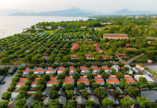 Vista aérea de tiendas safari y casas móviles en Villatent Outback, Campeggio del Garda, Italia, cerca del lago.