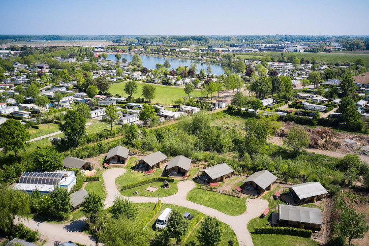 Aerial view of safari tents at Camping Betuwestrand in the Netherlands, overlooking the lake and greenery.