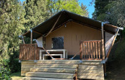 Tienda safari Villatent Wood en Camping Colleverde, Italia, rodeada de árboles y naturaleza, vista frontal.