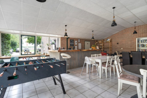 Sala ricreativa al Camping de Beukenhof con calcetto, bar, tavoli e sedie a Drenthe, Paesi Bassi.