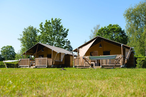 Twee safari-tenten, Villatent Outback, op Camping de Schatberg in Nederland, omgeven door groen.