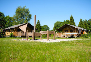 Safaritenten bij Villatent Outback op Camping de Schatberg in Nederland met grasveld en speelplek voor kinderen.