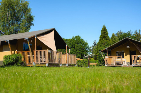 Safaritenten met houten terrassen op grasveld bij Villatent Outback, Camping de Schatberg, Nederland.